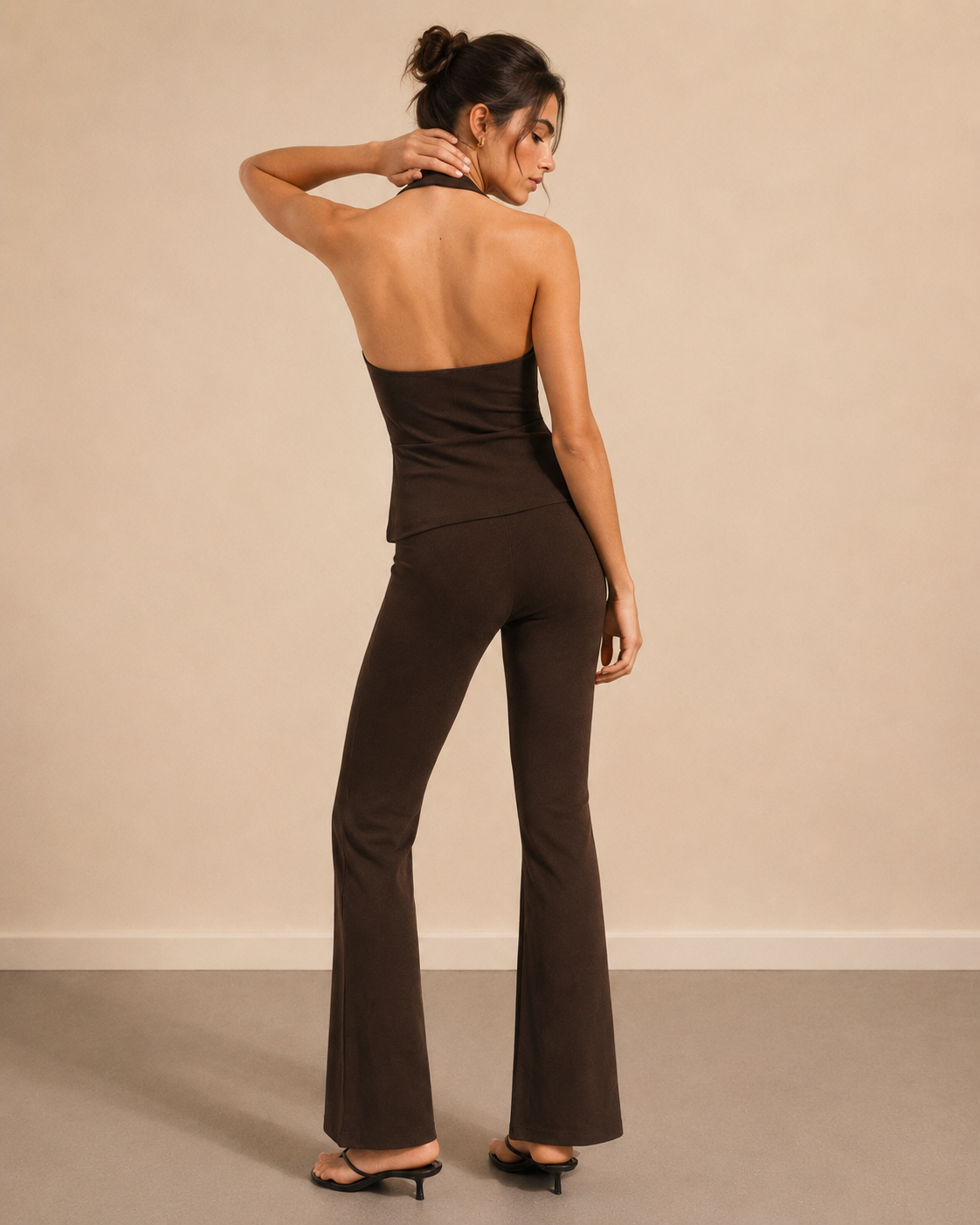Pantaloni stretch flare maro damă, vedere din spate, efect modelator și croială evazată.